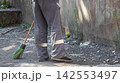Street Cleaner Sweeping Shattered Glass with Broom Close-Up 142553497