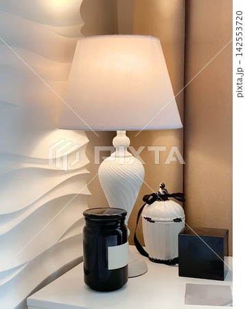 Elegant Table Lamp with Candle and Perfume on Minimalist Nightstand 142553720