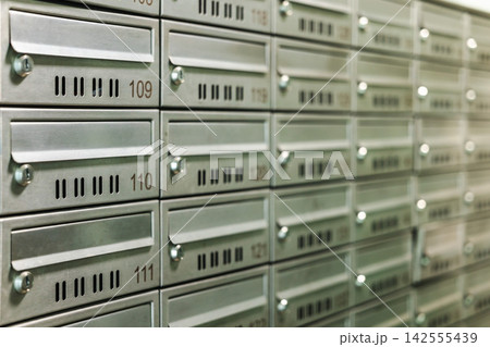 Close-up of Numbered Metal Mailboxes in Repeating Rows 142555439