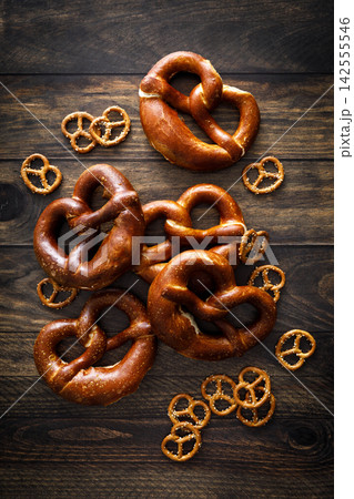 Pretzel bavarian soft baked brezel and mini snacks on dark wooden background Pretzel bavarian soft baked brezel and mini snacks on dark wooden background 142555546