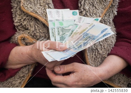 Elderly woman counting russian rubles illustrating high inflation and rising prices in 2026 Elderly woman counting russian rubles illustrating high inflation and rising prices in 2026 142555830