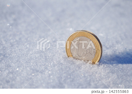 One Euro coin frozen in snow illustrating economic crisis and frozen assets concept One Euro coin frozen in snow illustrating economic crisis and frozen assets concept 142555863