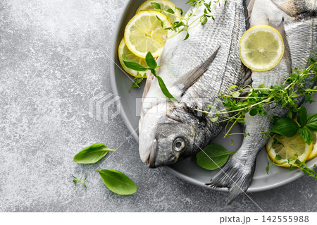 Fish raw dorado sea bream with lemon slices and herbs 142555988