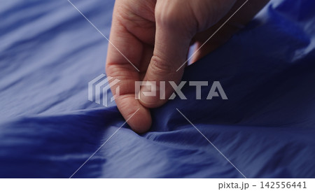 man hand checking blue synthetic bag fabric man hand checking blue synthetic bag fabric 142556441