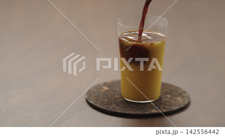 pour espresso in glass with orange juice to make Bumble coffee pour espresso in glass with orange juice to make Bumble coffee 142556442