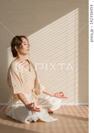 自宅でヨガと瞑想を実践する女性のヨガインストラクターイメージ 自宅でヨガと瞑想を実践する女性のヨガインストラクターイメージ 142556454