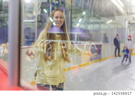 Woman ice skating alone at indoor rink, practicing winter sport, balance, active lifestyle and recreation in a bright public skating arena concept Woman ice skating alone at indoor rink, practicing winter sport, balance, active lifestyle and recreation in a bright public skating arena concept 142556917