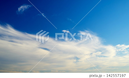 feathery white clouds scattered across the blue sky feathery white clouds scattered across the blue sky 142557197