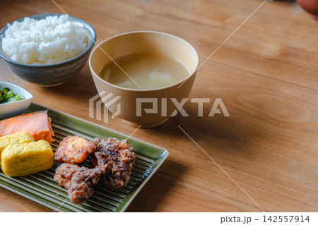 日本の食卓に並んだ家庭料理、焼き鮭と唐揚げ、ご飯と味噌汁の和定食。 142557914