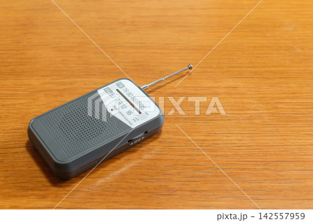 木製テーブルに置かれた防災用携帯ラジオと広いコピースペース 木製テーブルに置かれた防災用携帯ラジオと広いコピースペース 142557959