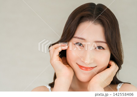 うるおいとハリのある美肌で笑顔を見せる40代女性のスキンケア 142558406