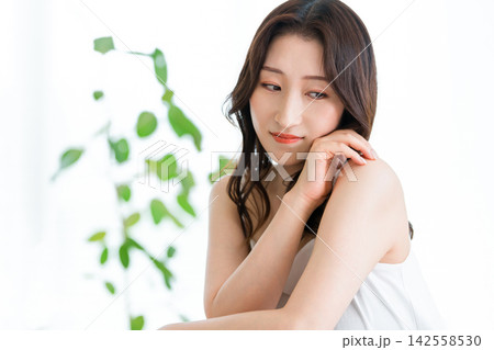 グリーンと自然光に包まれた美肌の40代女性。オーガニック自然派スキンケアの美容イメージ グリーンと自然光に包まれた美肌の40代女性。オーガニック自然派スキンケアの美容イメージ 142558530