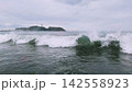 曇り空の湘南海岸から望む江の島と波しぶき 142558923