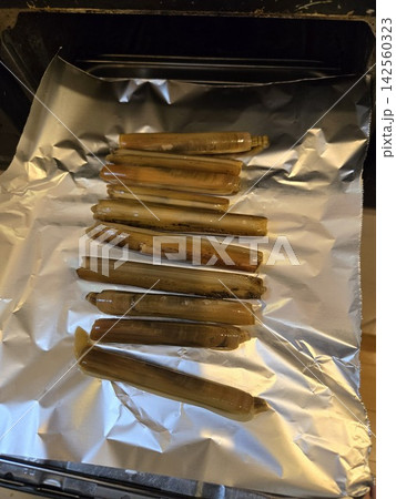 採取したマテガイをグリルで焼いて調理する写真 採取したマテガイをグリルで焼いて調理する写真 142560323