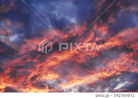 Colorful evening sky with orange and purple cumulus clouds creating dramatic background Colorful evening sky with orange and purple cumulus clouds creating dramatic background 142560972