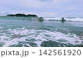 湘南の海に押し寄せる白波と遠くに見える江の島 142561920