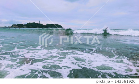 湘南の海に押し寄せる白波と遠くに見える江の島 142561920