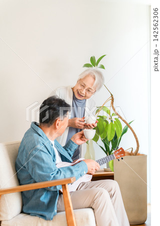 自宅でウクレレとコーヒーを楽しむ60代から70代のシニア夫婦。趣味を楽しむ豊かな老後とセカンドライフ 自宅でウクレレとコーヒーを楽しむ60代から70代のシニア夫婦。趣味を楽しむ豊かな老後とセカンドライフ 142562306