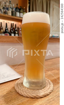 木のカウンターに置かれた泡立ちのよいビール 木のカウンターに置かれた泡立ちのよいビール 142564380