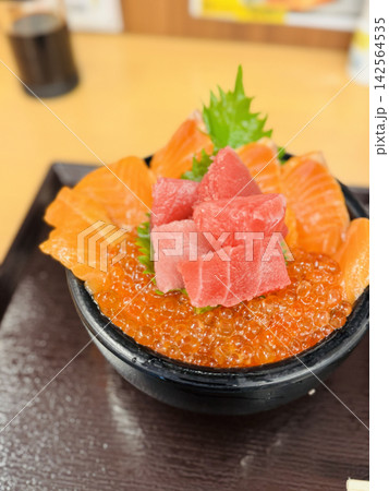 サーモンとマグロとイクラを盛り付けた豪華な海鮮丼 サーモンとマグロとイクラを盛り付けた豪華な海鮮丼 142564535