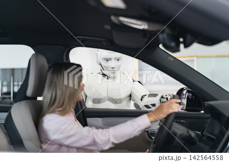 A humanoid robot interacts with a woman inside a car, suggesting a futuristic sales or service scenario A humanoid robot interacts with a woman inside a car, suggesting a futuristic sales or service scenario 142564558
