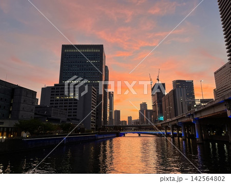 夕焼けに染まる大阪・中之島と堂島の高層ビル群と川の都市景観 夕焼けに染まる大阪・中之島と堂島の高層ビル群と川の都市景観 142564802