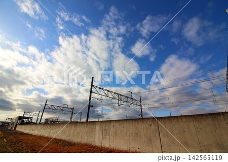 広がる雲と電車基地の電線 142565119