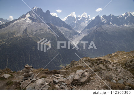 Mont blanc massif with hikers on a rocky trail 142565390