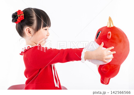Smiling little girl hugging a red ox plush toy, celebrating the Year of the Ox, Chinese New Year theme. 142566566