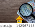 House model, money and magnifying glass for real estate investment 142567148