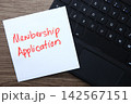 Membership application written on sticky note on laptop keyboard 142567151