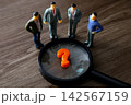 Miniature business people analyzing a question mark with a magnifying glass 142567159