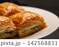 Traditional Turkish baklava served on a white plate close-up 142568831