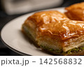 Traditional Turkish baklava served on a white plate close-up 142568832