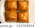 Traditional Turkish baklava served on a white plate close-up 142568834