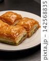 Traditional Turkish baklava served on a white plate close-up 142568835