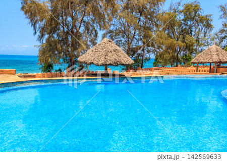 Swimming pool overlooking ocean. Tropical vacations concept Swimming pool overlooking ocean. Tropical vacations concept 142569633