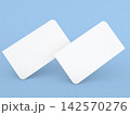 Two blank cards placed at an angle on a light blue background 142570276