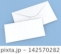 Blank envelope and card on a light blue background placed at a slight angle 142570282