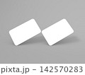 Blank business cards placed at an angle on a gray background for design 142570283