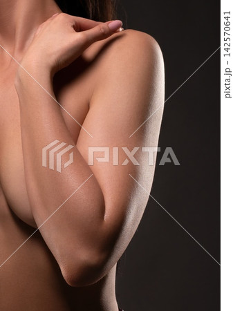 Close up of woman's arm across chest with hand on shoulder in studio 142570641