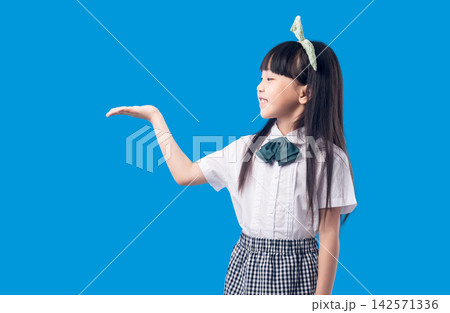 Asian School Girl Presenting Empty Space with Open Hand Gesture Asian School Girl Presenting Empty Space with Open Hand Gesture 142571336