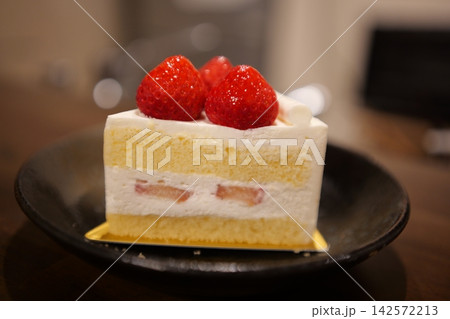 木のテーブルに置かれたカフェ風のイチゴショートケーキ 木のテーブルに置かれたカフェ風のイチゴショートケーキ 142572213