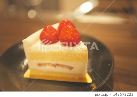 木のテーブルに置かれたカフェ風のイチゴショートケーキ 142572222
