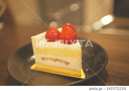 木のテーブルに置かれたカフェ風のイチゴショートケーキ 142572228