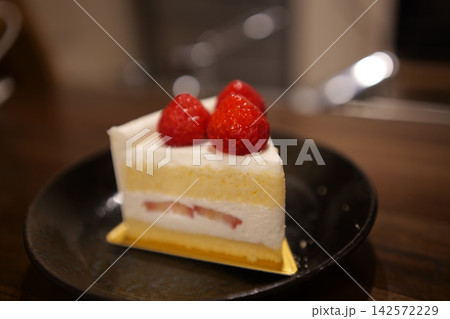 木のテーブルに置かれたカフェ風のイチゴショートケーキ 142572229
