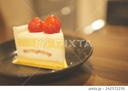木のテーブルに置かれたカフェ風のイチゴショートケーキ 142572230