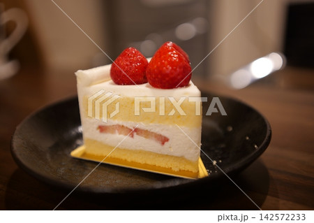 木のテーブルに置かれたカフェ風のイチゴショートケーキ 142572233