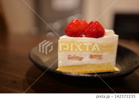 木のテーブルに置かれたカフェ風のイチゴショートケーキ 142572235