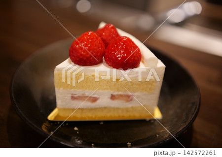 木のテーブルに置かれたカフェ風のイチゴショートケーキ 木のテーブルに置かれたカフェ風のイチゴショートケーキ 142572261